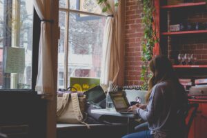 a woman working at home at a desk in front of her window, to represent flexible working